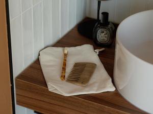 a brush sitting on a towel on a floor next to a toilet at Hôtel Fort St Laurent Lyon - Handwritten Collection in Lyon
