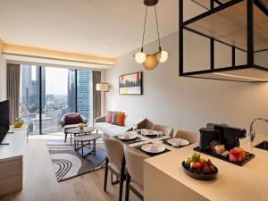 sala de estar con cocina y sala de estar con mesa en Swissôtel Living Jakarta Mega Kuningan, en Yakarta