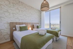 a bedroom with two beds and a window at Bayline XV in Armação de Pêra