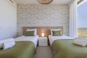 two twin beds in a room with a window at Bayline XV in Armação de Pêra