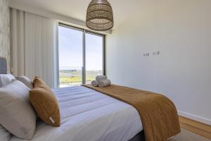 a bedroom with a large bed with a large window at Bayline XV in Armação de Pêra