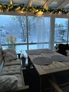 a table and a couch in front of a window at Havuille Lodge in Rovaniemi