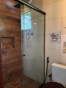 a glass shower in a bathroom with a toilet at Chácara do Conde in Mangaratiba