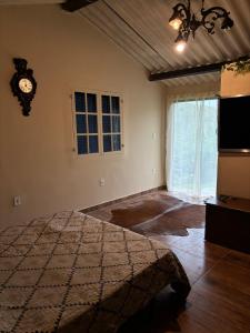 a bedroom with a bed and a clock on the wall at Chácara do Conde in Mangaratiba