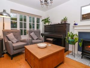 a living room with a piano and chairs and a table at Lair Close House in Harrogate