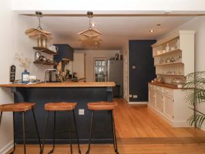 a kitchen with a counter and stools in it at Lair Close House in Harrogate