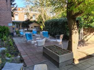 eine Terrasse mit blau-weißen Stühlen und einem Baum in der Unterkunft Boutiquehotel Staats in Haarlem