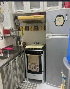 een keuken met een fornuis en een koelkast bij Quarto Suite Barra Réveillon Salvador in Salvador