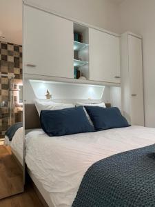 a bedroom with a large white bed with blue pillows at Le Laurencin Sens - La Plage - Cœur de ville in Sens
