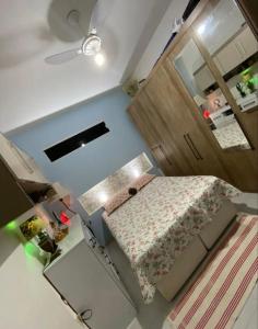 een kleine slaapkamer met een bed en een spiegel bij Quarto Suite Barra Réveillon Salvador in Salvador