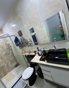 een kleine badkamer met een wastafel en een douche bij Quarto Suite Barra Réveillon Salvador in Salvador