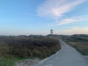a path leading to a lighthouse on a hill at Haus Kalmar in Langeoog