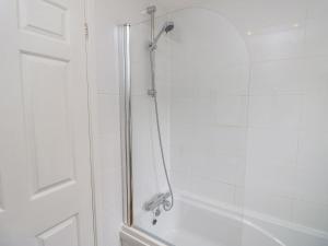 a shower with a glass door next to a tub at Harbour View Poole in Poole +25 photos