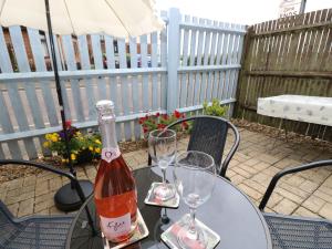 a bottle of wine sitting on a table with two glasses at Harbour View Poole in Poole