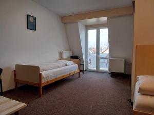 a bedroom with a bed and a large window at Gästehaus Langhammer in Bubenreuth