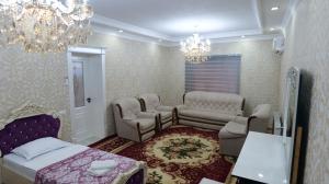 een slaapkamer met een bed en stoelen en een kroonluchter bij RegistanStay - Private House 2 Min Walk to Registan in Samarkand