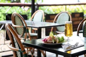 a table with a plate of food and a glass of beer at Hotel Bishops Arms Kristianstad in Kristianstad
