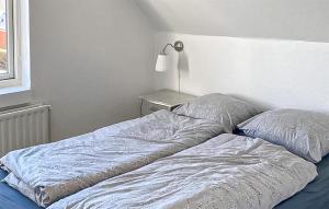 Una cama deshecha con dos almohadas encima en Cozy Apartment In Varde With Wifi, en Varde