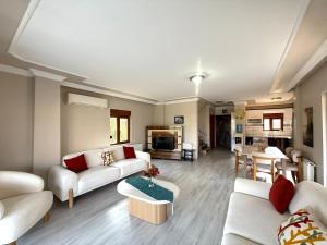 un soggiorno con due divani e un tavolo di Family Duplex Villa with Garden 150m to Beach a Ayvalık