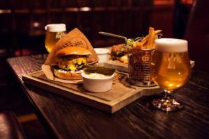 a table with a sandwich and two glasses of beer at Hotel Bishops Arms Kristianstad in Kristianstad +23 photos