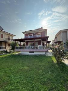 una grande casa con un prato davanti di Family Duplex Villa with Garden 150m to Beach a Ayvalık