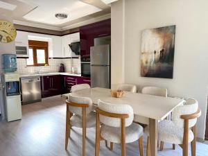una cucina con un tavolo e sedie in una stanza di Family Duplex Villa with Garden 150m to Beach a Ayvalık