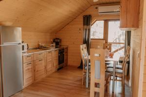 a kitchen with a refrigerator and a table with chairs at Sosnowy Domek Piętro Zator Graboszyce Energylandia in Graboszyce
