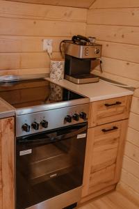a kitchen with a stove and a coffee maker at Sosnowy Domek Piętro Zator Graboszyce Energylandia in Graboszyce +4 photos