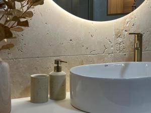 een badkamer met een witte wastafel en 2 kaarsen bij Cisowa Garden Suite in Świdnik +22 foto's