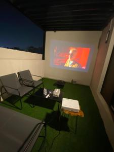 een kamer met 2 stoelen en een projectiescherm bij Velora Serviced Apartments in Al Khobar