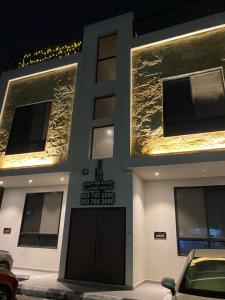 een gebouw met een auto geparkeerd op een parkeerplaats bij Velora Serviced Apartments in Al Khobar