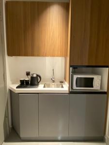 een keuken met een spoelbak en een magnetron bij Velora Serviced Apartments in Al Khobar