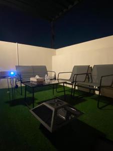 een patio met stoelen en een tafel met een blauw licht bij Velora Serviced Apartments in Al Khobar +2 foto's