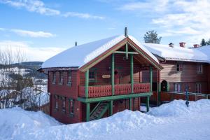a large wooden house with snow on the ground at Sjumilskogen in Trysil