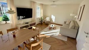 a living room with a table and a couch and a television at Haus Monterosa in Sankt Johann im Pongau