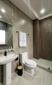 a bathroom with a white toilet and a sink at Van park hotel in Shymkent
