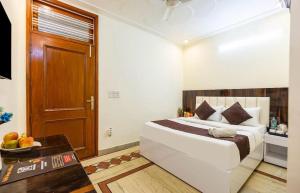 um quarto com uma cama, uma mesa e uma porta em Hotel Emerald Suites & Banquet By Aura em Noida