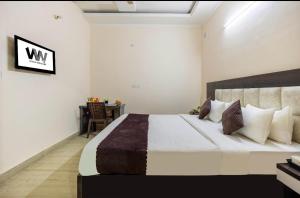 um quarto com uma cama grande e uma escrivaninha em Hotel Emerald Suites & Banquet By Aura em Noida