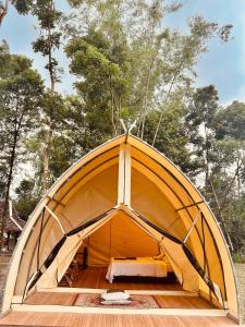 a large orange tent with a bed in it at Kayi glamping in Kaliurang +4 photos