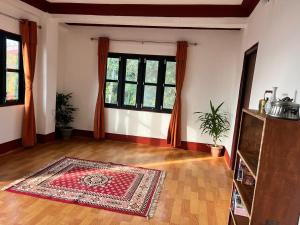 sala de estar con alfombra en el suelo de madera en Nest- 5BR Mountain Villa Bandipur, en Bandipur