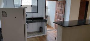 eine Küche mit Kühlschrank und Arbeitsplatte in der Unterkunft Casa de 01 quarto para temporada in Marataizes