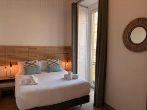 a bedroom with a large white bed with a mirror at Life Apartments Arcos 27 in Jerez de la Frontera