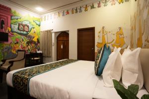 a bedroom with a bed and a painting on the wall at Stamps By Eight Continents, Pushkar in Pushkar