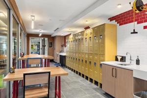 a locker room with yellow lockers and tables in a room at Kasa Rino Denver in Denver