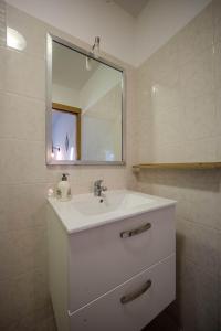 ein Badezimmer mit einem weißen Waschbecken und einem Spiegel in der Unterkunft Appartement Dauphin - Résidence Kiwi in Aytré