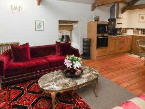 een woonkamer met een rode bank en een tafel bij The Classic in Falstone