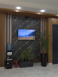 a flat screen tv on a wall in a lobby at NiNi HOSTEL in Tashkent