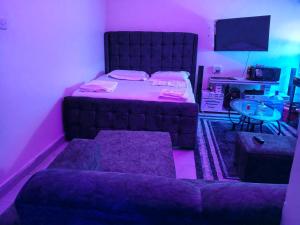 een slaapkamer met een bed, een bank en een tafel bij Goshen heights in Kitengela 