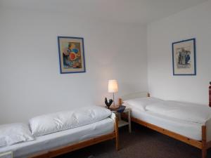 two beds in a room with white walls at Gästehaus Langhammer in Bubenreuth