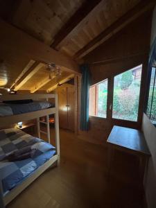 a bedroom with a bunk bed in a log cabin at Chalet les vergers in Sallanches +25 photos